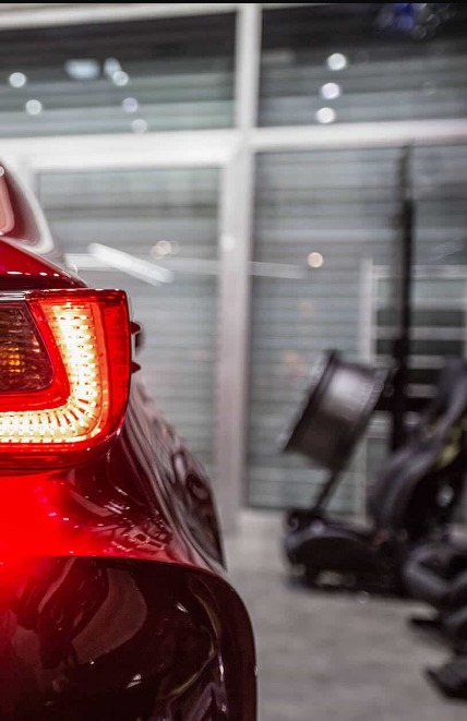 Rear of a red sports car in a workshop